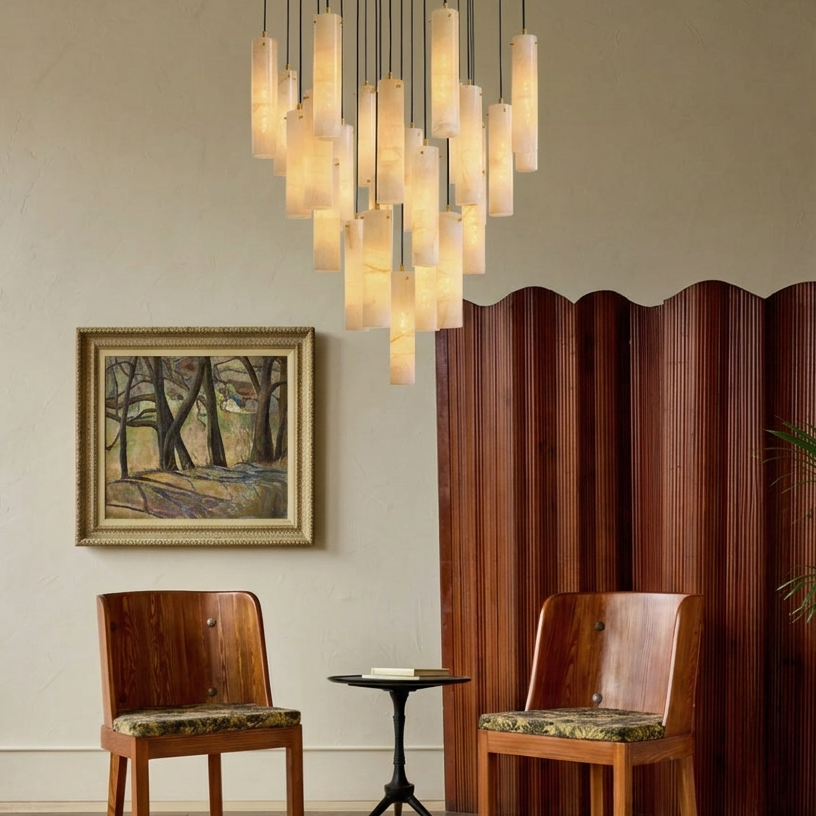 Two wooden chairs with patterned cushions in a room with a chandelier, painting, and wooden screen.