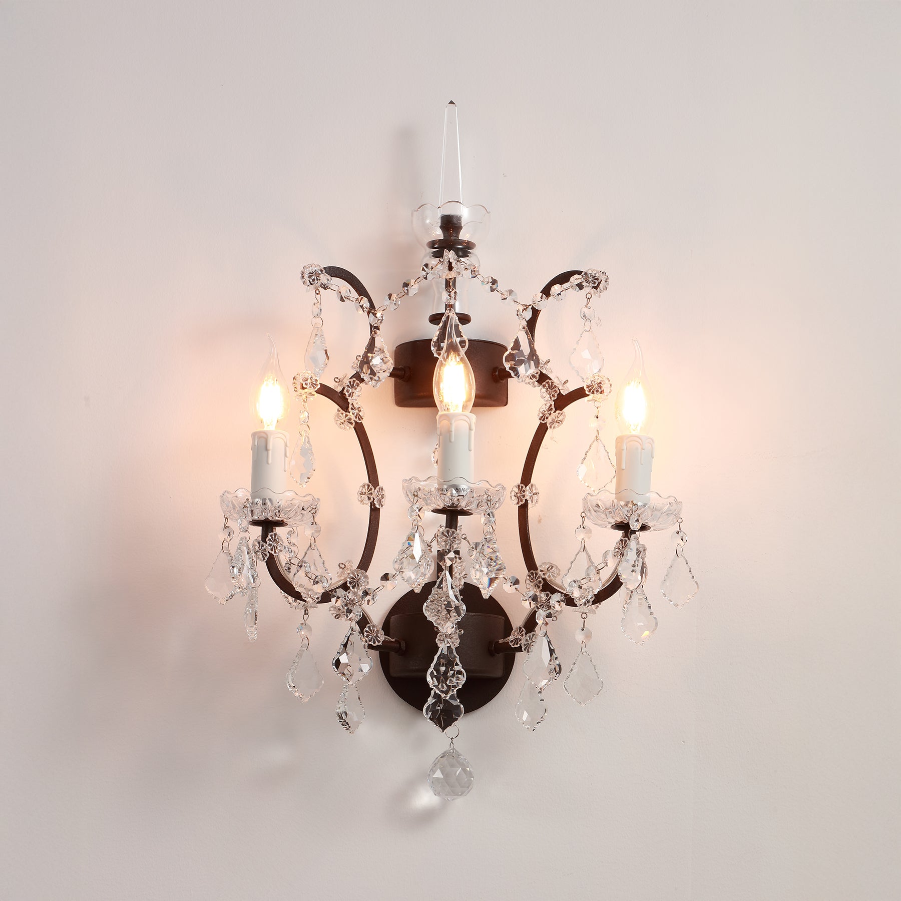 Decorative wall sconce with crystal accents on a plain background