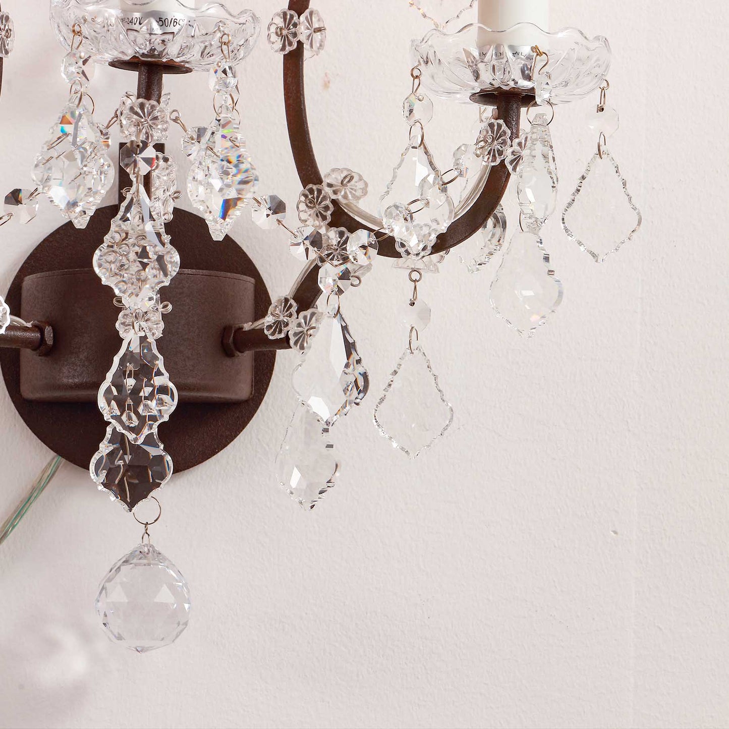 Close-up of a decorative wall sconce with crystal elements on a light background